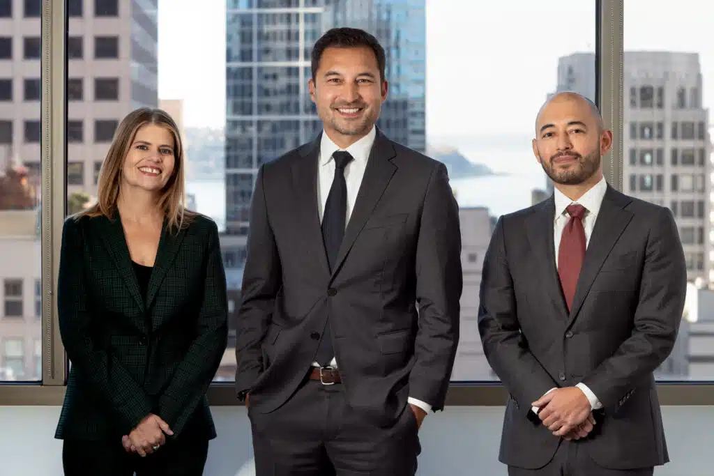 Managing partners of Oslund Udo Little pose by a window.