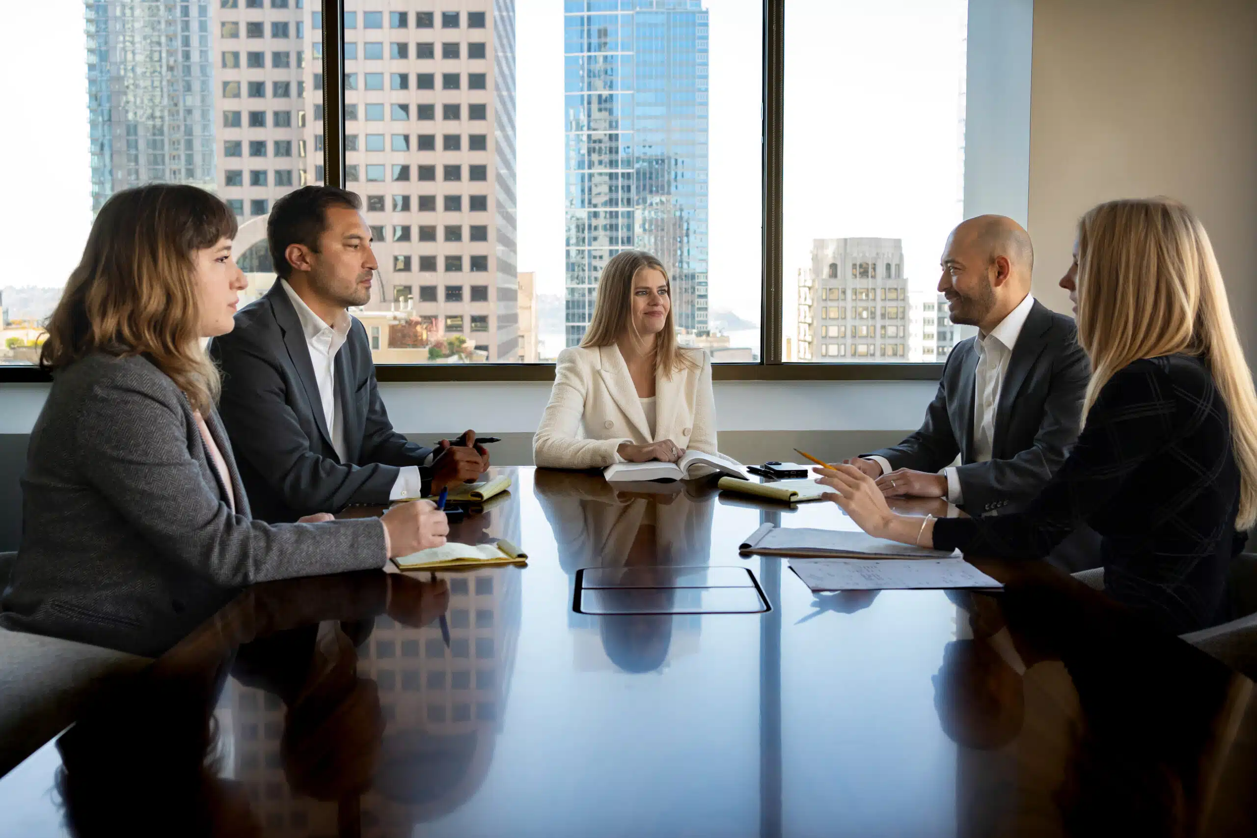 Five asbestos attorneys and partners discuss at a conference table at Oslund Udo Little.