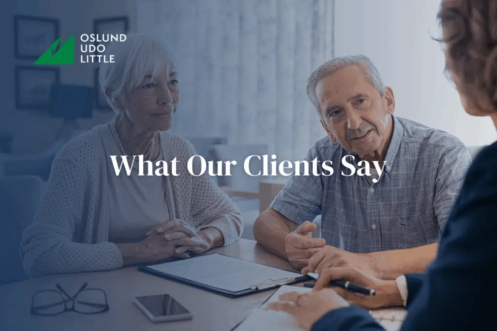 What Our Clients Say: A lawyer sitting at a table talking with a couple
